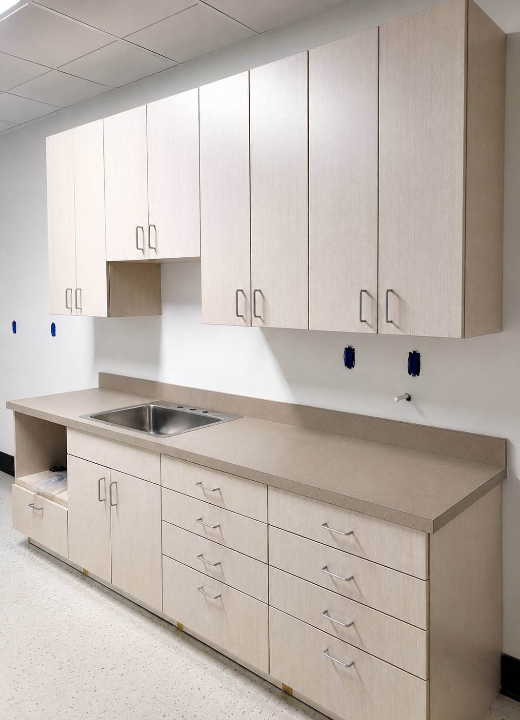 Pale wood kitchenette with stainless sink